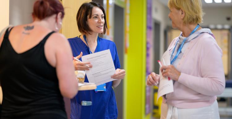 three women in a hospital completing questionnaires