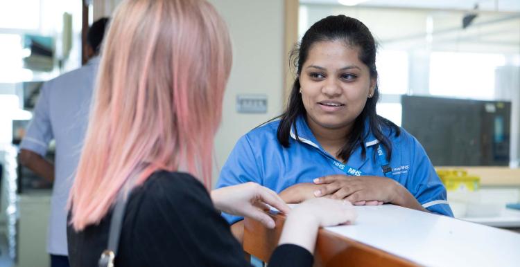 A female nurse talking to a patient in a hospital setting