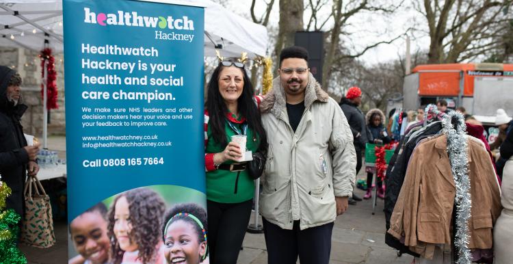 two people standing beside Healthwatch pop up banner