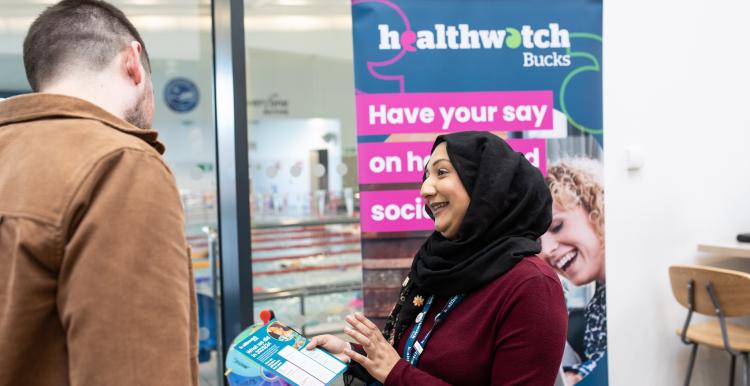 person speaking to Healthwatch representative at event