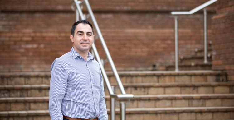 Man wearing smart clothes stood on an outside flight of stairs