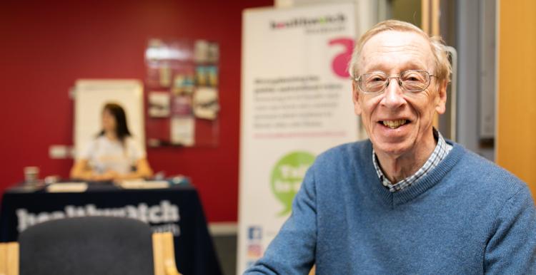 Man looking directly at camera with Healthwatch branding behind Man looking directly at camera with Healthwatch branding behind