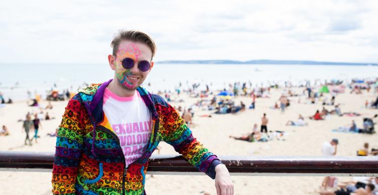 Man with colourful face paints standing in front of a beach Man with colourful face paints standing in front of a beach