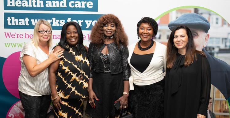 Five women standing in front of Healthwatch background