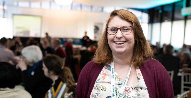 Woman with glasses wearing lanyard