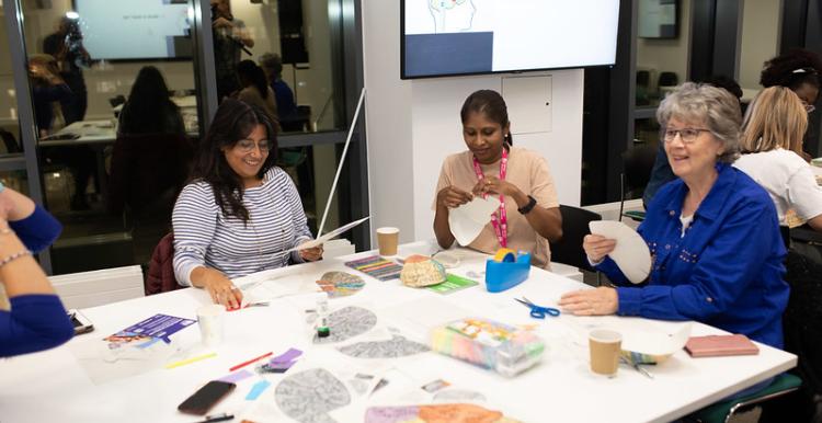 Three women sitting around a table looking at paperwork