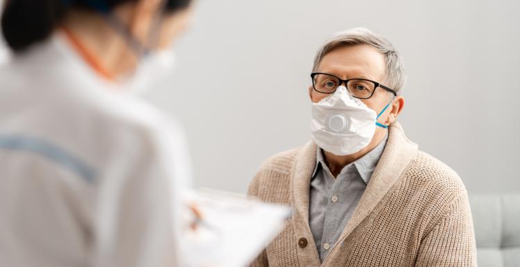 Doctor and senior man wearing facemasks during coronavirus outbreak.