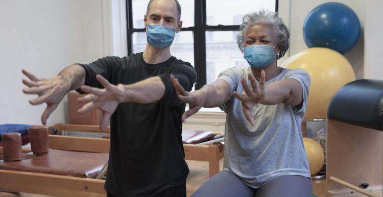 A man and women doing exercise at rehab center wearing masks A man and women doing exercise at rehab center wearing masks
