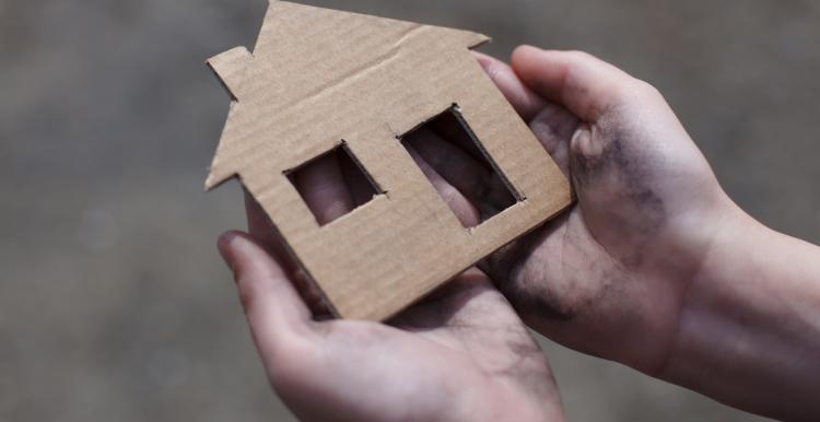 Person holding shape of a home in their hands