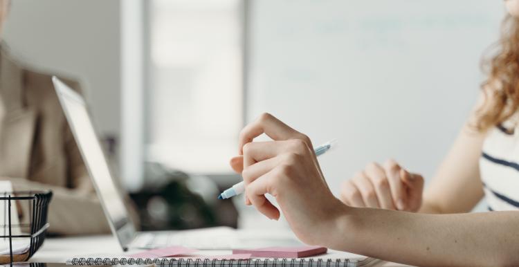 Person Holding a Pen Writing on a Paper