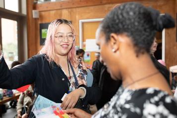 Two people smiling and talking at a Healthwatch event