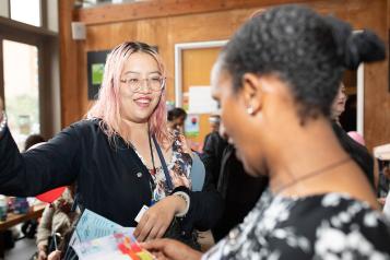 Two people smiling and talking at a Healthwatch event 