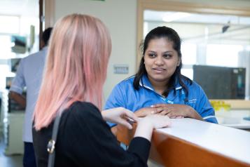 A female nurse talking to a patient in a hospital setting
