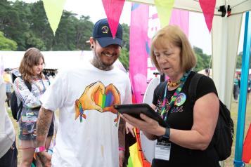 Woman with clipboard talking to man in baseball cap