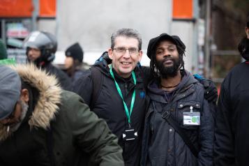 Two men smiling at the camera with arms around each other
