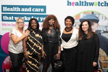 Five women standing in front of Healthwatch background