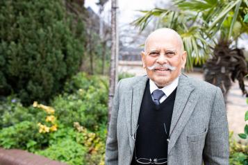 Older man standing outside, with a moustache