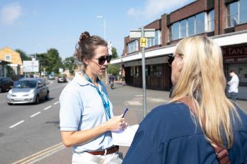 Two Healthwatch staff fill in a form.