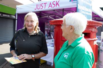 Two women at an outdoor event chatting