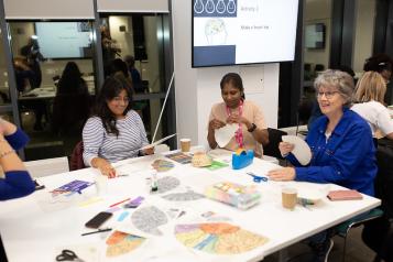 Three women sitting around a table looking at paperwork