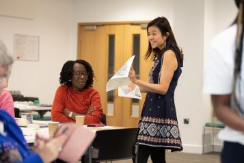 Woman standing in front of a room of people giving a speech