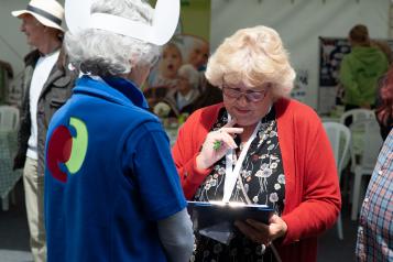 Healthwatch volunteer talking to a lady with a clipboard