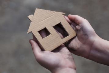 Person holding shape of a home in their hands
