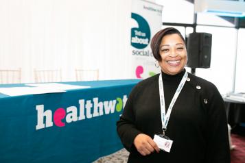 Healthwatch staff member standing in front of a stall