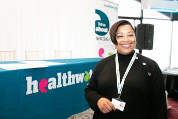 Healthwatch staff member standing in front of a stall 