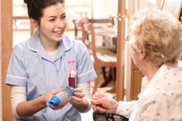 Nurse smiling at an old lady in a care home. 