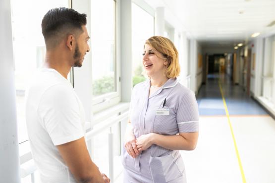 Man talking to a nurse in hospital corridor Man talking to a nurse in hospital corridor