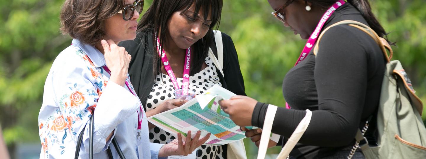 Three people looking at a leaflet